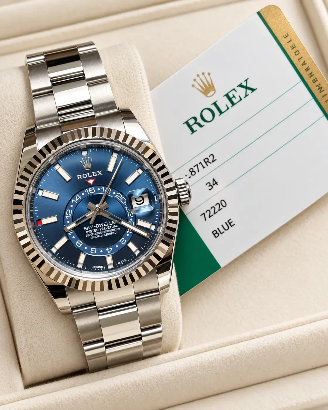Steel Sky-Dweller with a blue dial resting in its presentation box beside its card